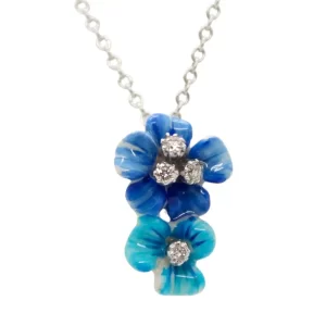 two vertically stacked enamel flowers with diamond centers; bottom flower is teal, top flower is dark blue