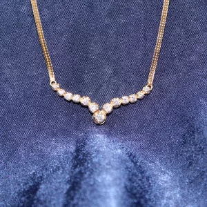 shallow V of diamonds; a center diamond with 6 graduated diamonds on each side attached to a flat chain