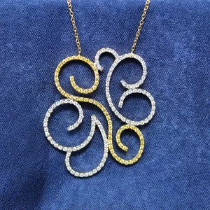 yellow and white diamonds in a large scroll pattern set in yellow gold and attached to a chain