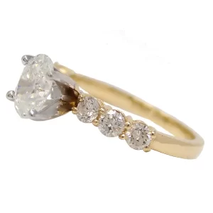yellow gold band with round center diamond in white gold head and 3 accent diamonds are each side of the center diamond
