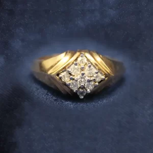 9 round diamonds clustered into a rotated square and set in a wide, stylized gold band