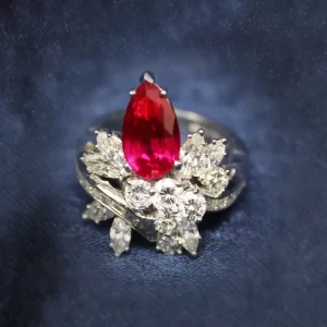 pear ruby with round, marquise, and baguette diamonds at the round bottom of the ruby