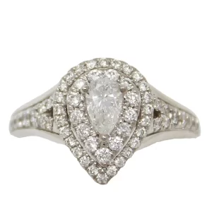 pear center diamond surrounded by a double halo of round diamonds in a pear shape; round diamonds accent the shoulders
