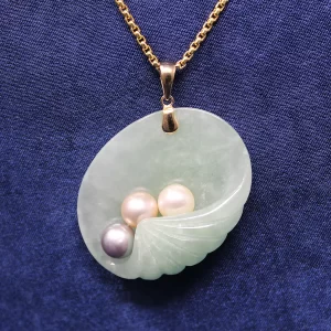 shell-shape jade pendant with a gray, pink, and white pearl on a yellow gold box chaine